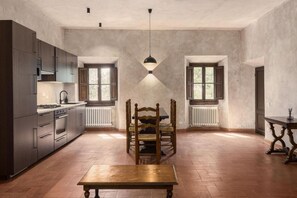 A spacious kitchen with modern appliances, a dining table, and a pendant light. - Poggio 3 Lune (Rignano sull'Arno)