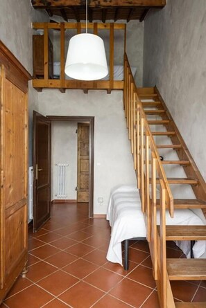 A staircase with wooden railings and a white pendant light. - Poggio 3 Lune (Rignano sull'Arno)