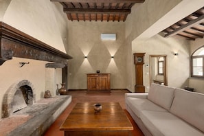 A room with a fireplace, a sofa, a wooden table, and a cabinet.