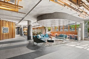Eine großzügige Lobby mit gewölbter Decke, Sitzbereichen und Blick ins Freie.