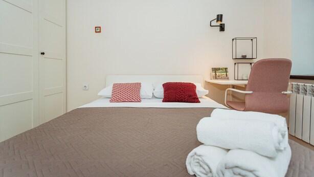 Ein Hotelzimmer mit einem Bett, einem Sessel, einem Schreibtisch und einer Heizung.