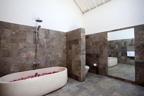 A modern bathroom with a freestanding bathtub, a showerhead, and a toilet. - Villa Alma (Badung)