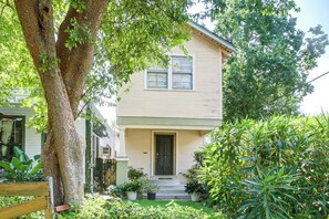 A two-story house with a front porch, a black door, and a window with a shutter. - Walk to Shops & Restaurants! NOLA Extended Stay (New Orleans)