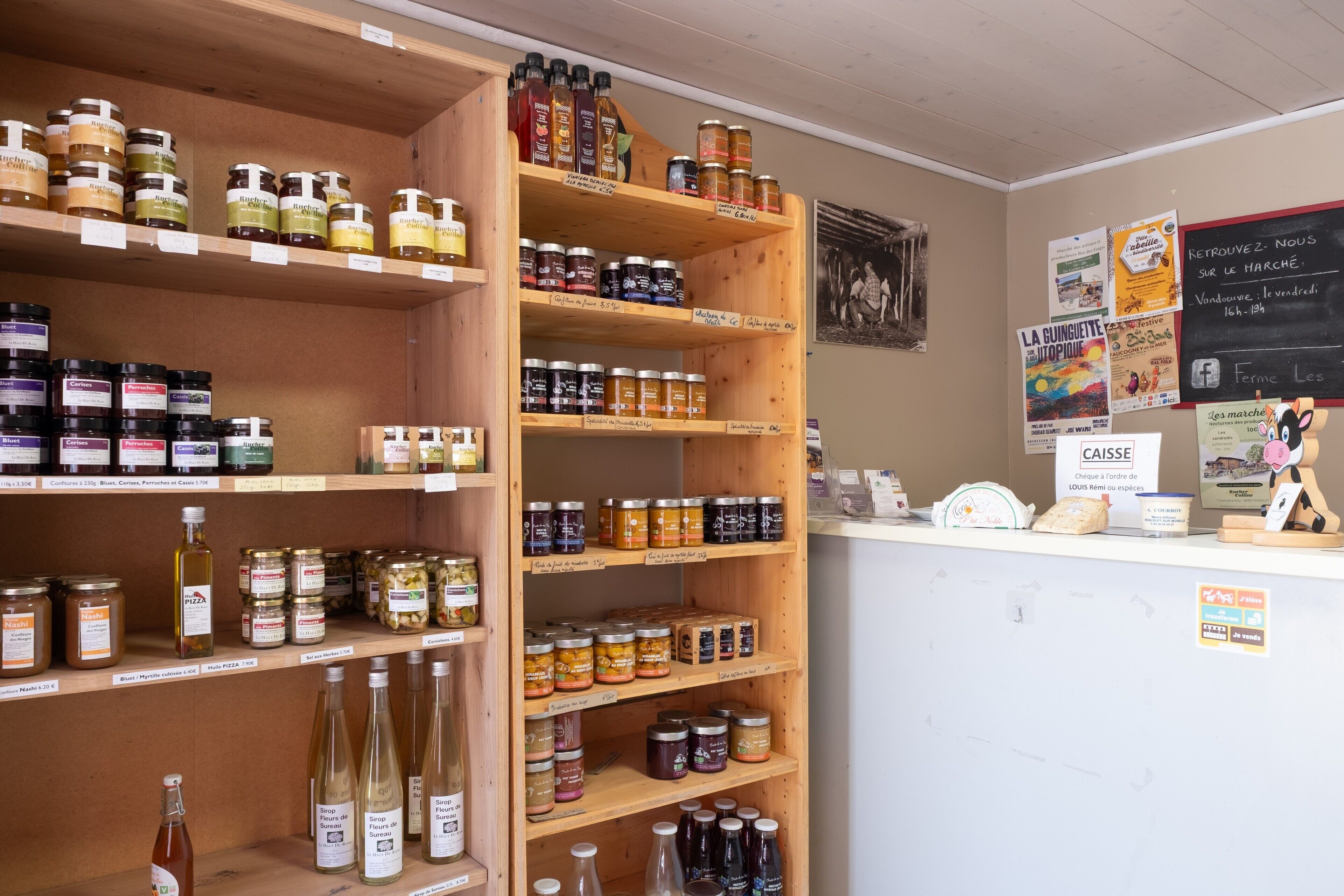 Un magasin dont les étagères sont remplies de différents pots de confitures et de bouteilles de liquides.