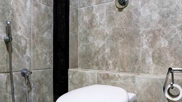 Un baño con inodoro, ducha y bidé.