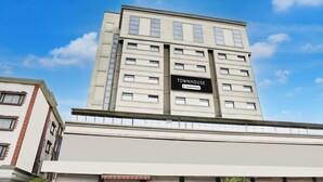 Un immeuble à plusieurs étages, sur lequel on peut lire l’inscription : « TOWNHOUSE, entreprise offrant des services. »