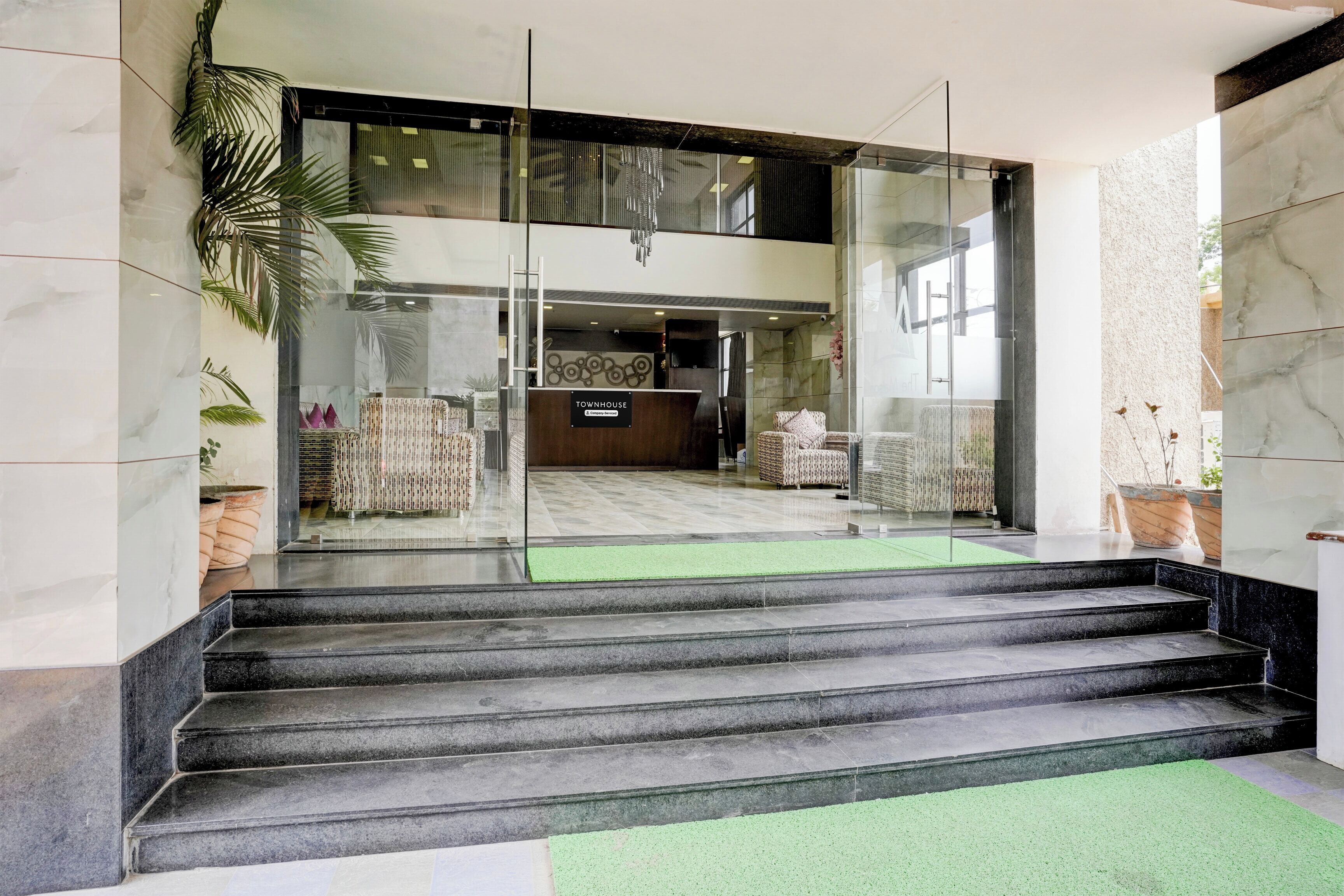 Un hall d’hôtel comprenant un comptoir d’accueil, un espace salon et un escalier menant à l’étage supérieur.