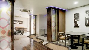 Un restaurant doté d’un long comptoir en bois, de plusieurs tables et de chaises.