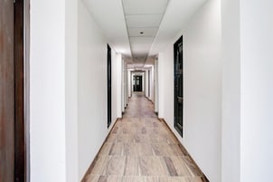 A long, narrow hallway with white walls and a wooden floor.