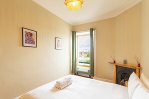Ein Hotelzimmer mit Bett, Kamin und einem Vorhangfenster.