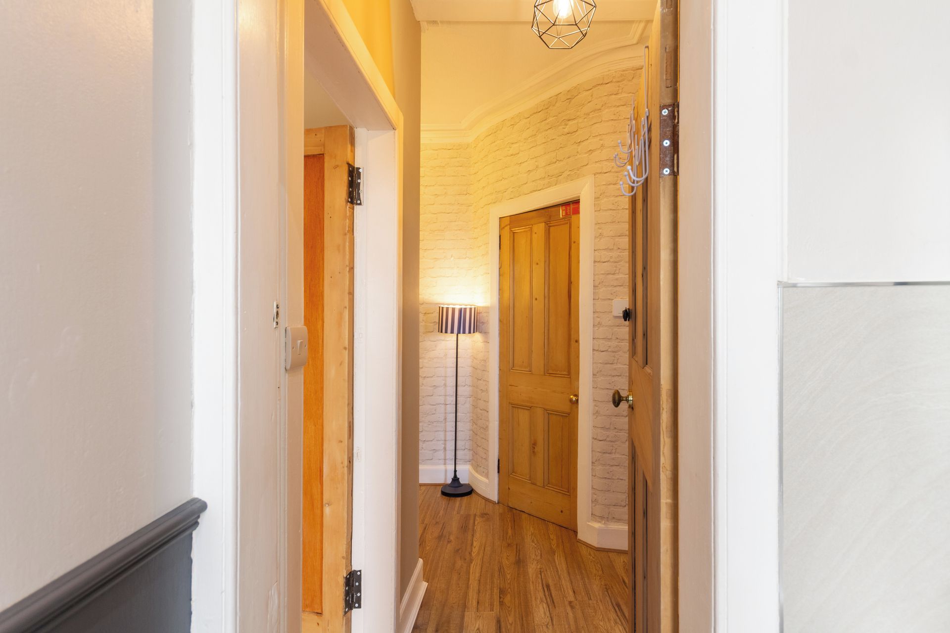A hallway with wooden doors, a lamp, and a light fixture.