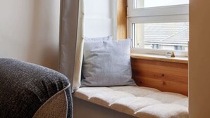 A corner of a room with a window, a cushion, and a piece of furniture. - Serene 2BDR Flat Near Edinburgh Old Town (Edinburgh)