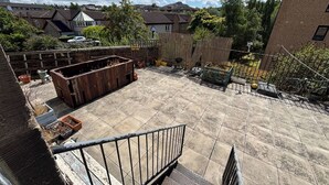 A rooftop patio with a metal railing, potted plants, and a view of surrounding buildings. - Serene 2BDR Flat Near Edinburgh Old Town (Edinburgh)