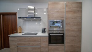 Uma cozinha moderna com forno embutido, micro-ondas e exaustor.