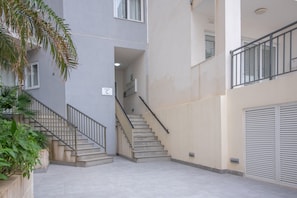 Ein mehrgeschossiges Gebäude mit einer zentralen Treppe, einer Garagentür und einem Schild mit dem Standort.