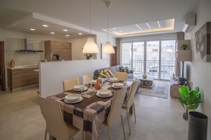Eine moderne Wohnung mit Essbereich, Küche und Balkon.