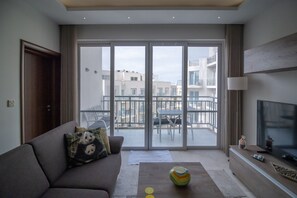 Ein modernes Wohnzimmer mit einer Couch, einem Couchtisch und einem Fernseher.