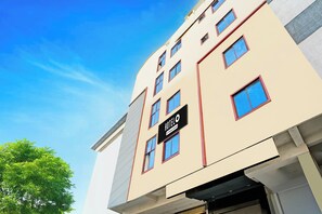 Un immeuble hôtelier à plusieurs étages, avec une enseigne indiquant qu’il s’agit d’un hôtel géré par une entreprise.