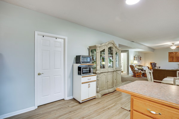 A room with a white door, a microwave on a white cabinet, a wooden cabinet with glass doors, and a wooden counter. - Studio Suite & Country Views! Sibley Group Retreat (Sibley)