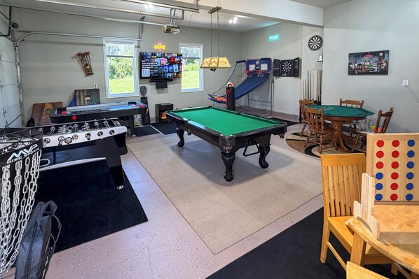 Sala de recreación con mesa de billar, mesa de futbolín, dardos y mesa de billar.