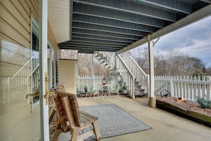A covered porch with a wooden bench, a small table with chairs, and a staircase leading to a deck. - Studio Suite & Country Views! Sibley Group Retreat (Sibley)