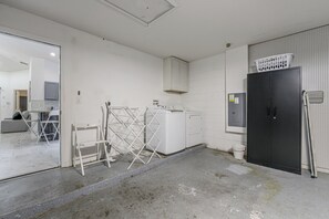 A laundry room with a washing machine, drying rack, and a utility cabinet. - Poolside Fun 8 Mi to Disney! Family Getaway (Kissimmee)