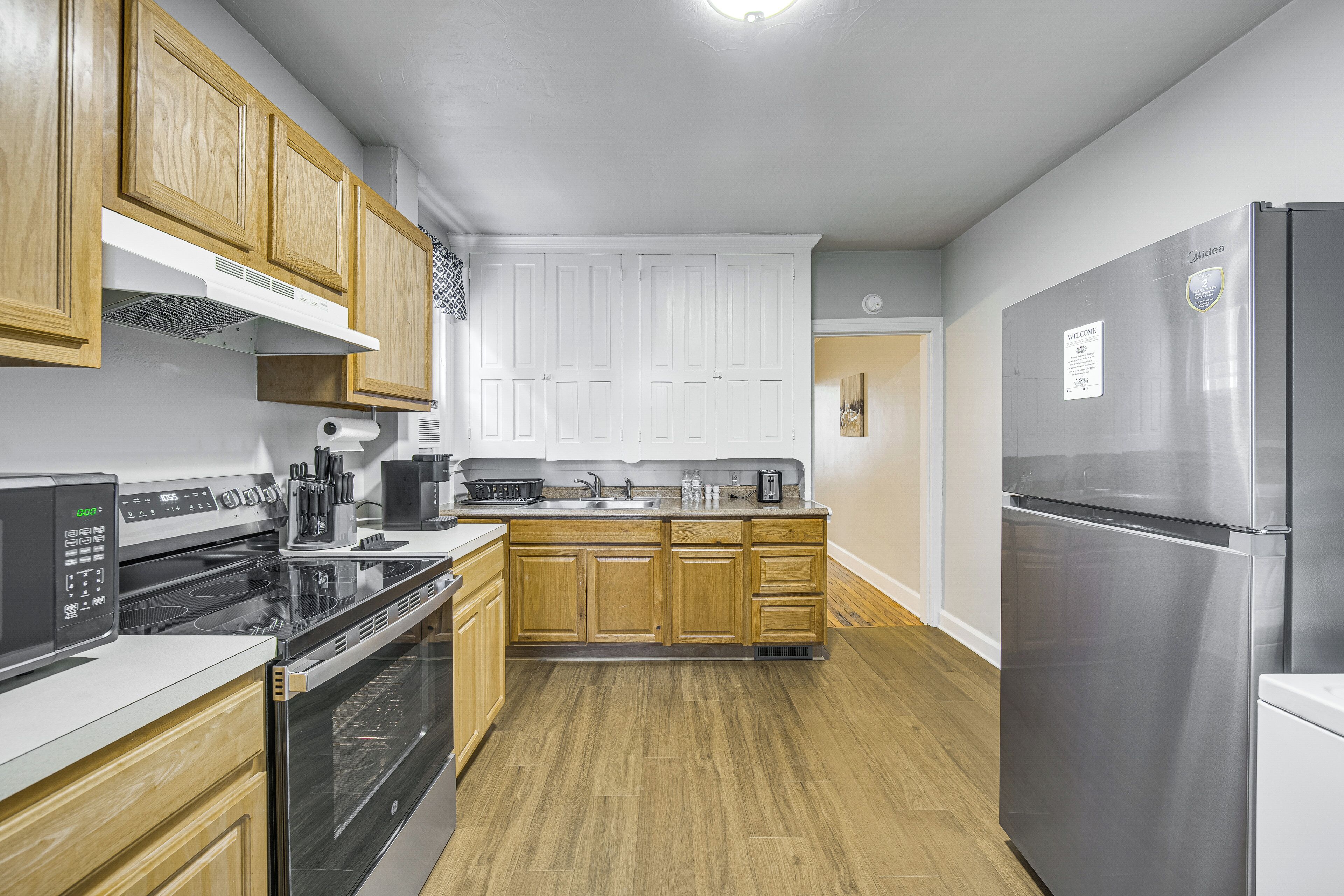 Una cocina moderna con armarios de madera, electrodomésticos de acero inoxidable y una isla central.