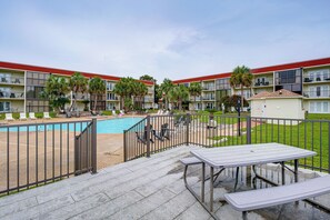 Ein Hotel mit Schwimmbad, Sitzgelegenheiten im Freien und einem eingezäunten Patio.