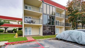 A multi-story building with balconies, a covered parking area, and a fire hydrant. - Walk to Beach! Biloxi Condo w/ Community Perks (Biloxi)