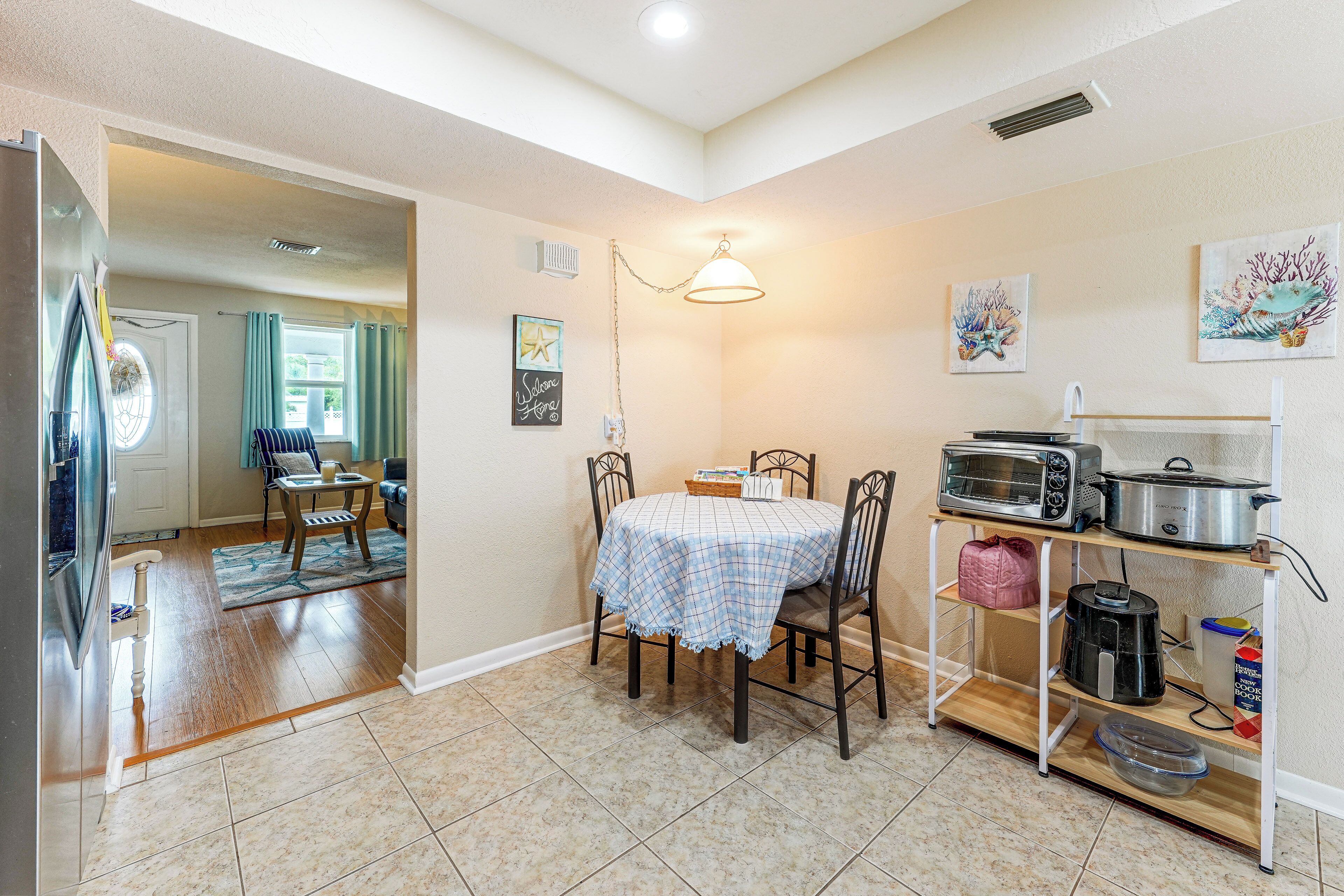 A compact kitchen with a dining table, chairs, a microwave, a toaster, and a coffee maker.
