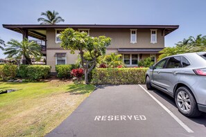 A building with a parking area marked 'RESERVED' and a parked car. - Halii Kai Condo Close in Proximity to Ocean/Pool (Waikoloa Village)