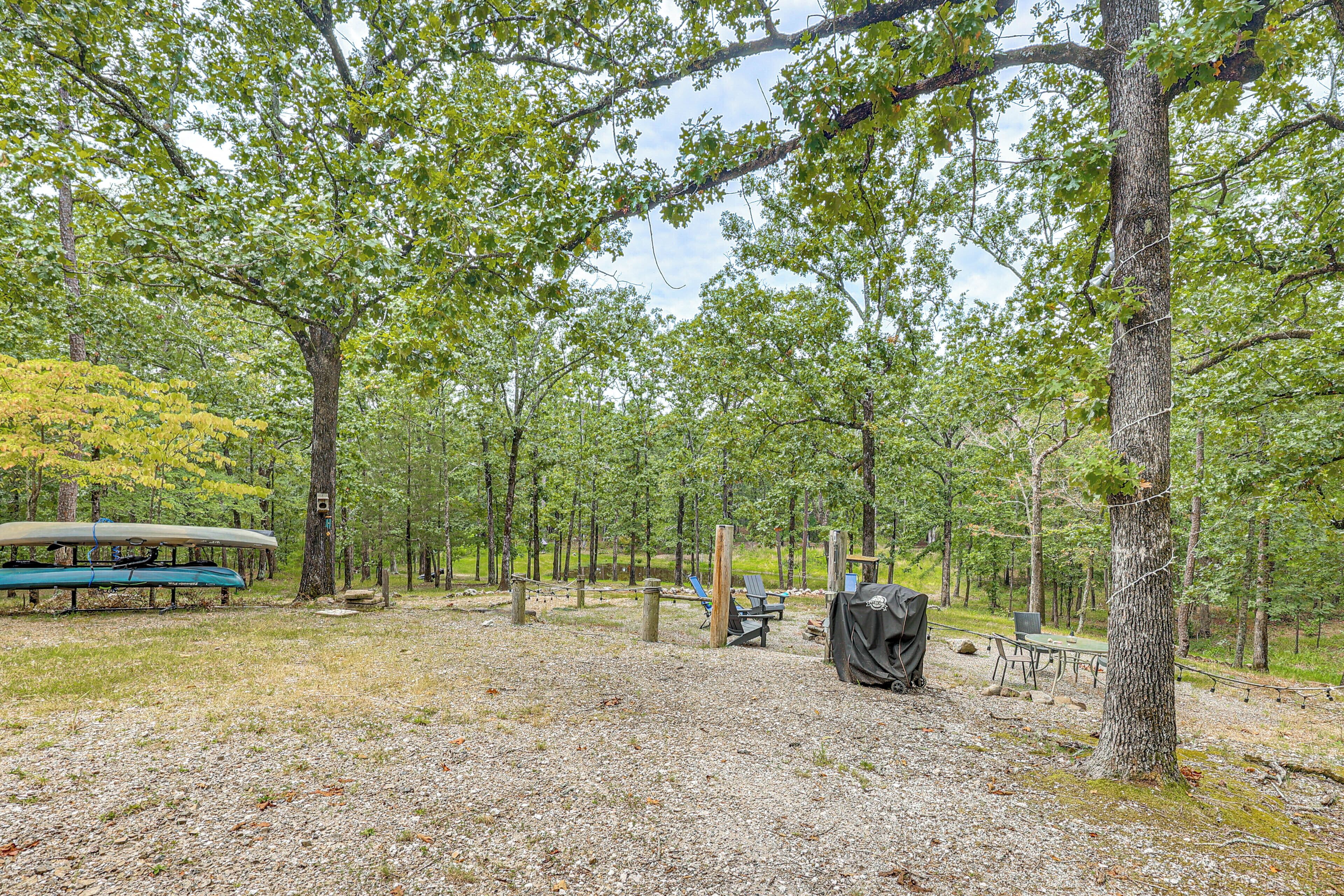 A campground with picnic tables, a covered area, and a canoe.
