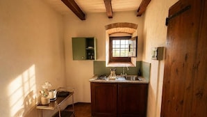 Una cocina compacta con encimera de madera, un lavamanos y una ventana sobre él.