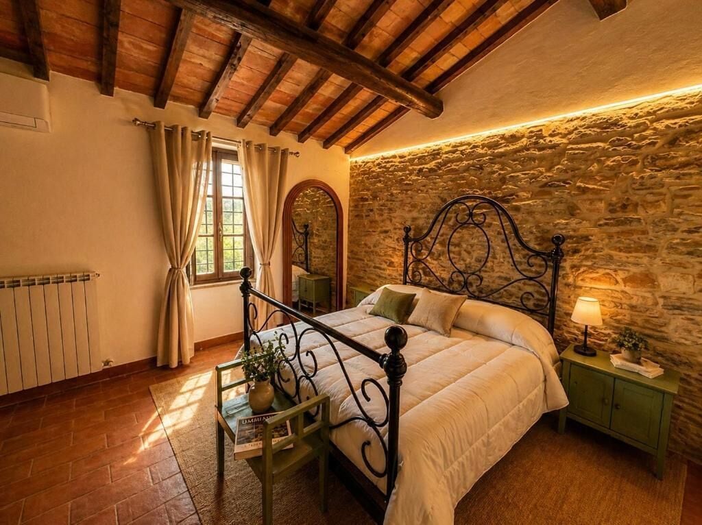 Una camera da letto con parete in pietra, soffitto in legno, un letto con struttura in metallo, un comodino con una lampada e una finestra con tende.