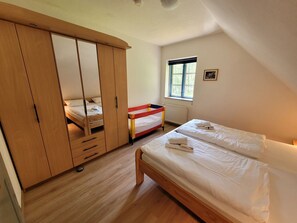 A bedroom with a bunk bed, a wardrobe, and a window. - Kollhof Rügen Lauterbach - Kollhof Rügen - Pure relaxation in absolute tranquility in (Putbus)