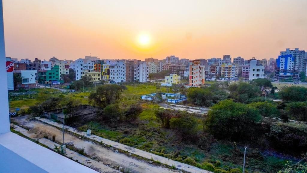 Zona residencial con varios edificios de apartamentos, cielo despejado y atardecer.