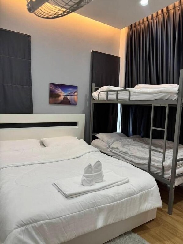 Habitación de hotel con literas, una cama individual y un par de zapatos sobre la cama.