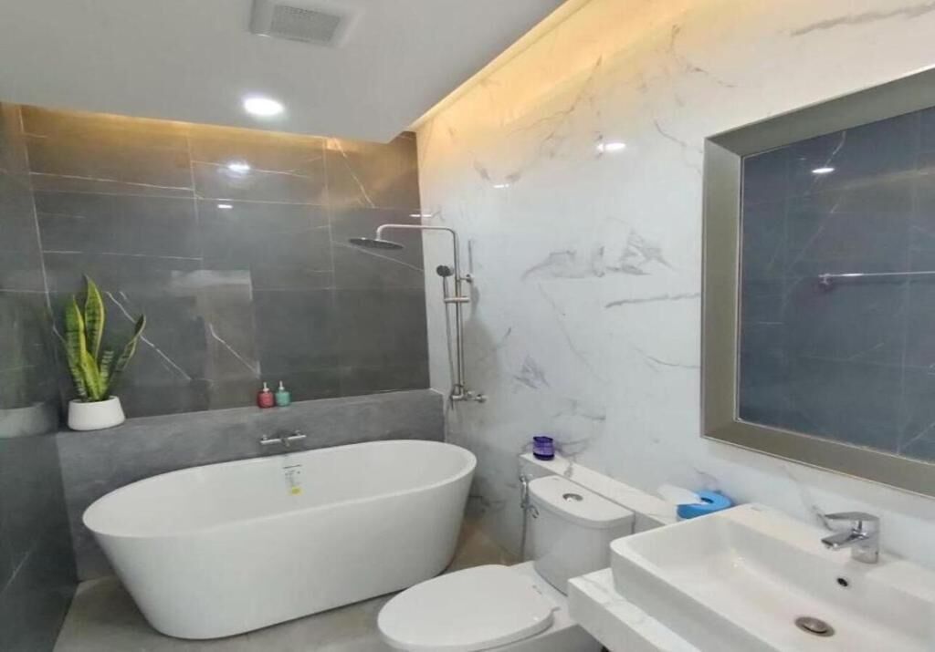 Un baño moderno con una bañera independiente, inodoro y lavamanos.