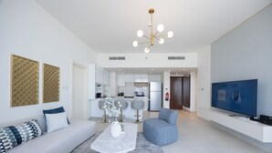 A modern living room with a sofa, coffee table, and a television. - Bloomfields 2BR in The Bridges - Reem (Abu Dhabi)
