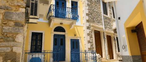 A building with a stone facade, a yellow and blue color scheme, and a blue door.