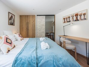 A hotel room with a bed, a desk, and a chair. - Chalet 4BR – Nordic bath – parking and garage (Chamonix)
