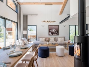 A modern living room with a sofa, coffee table, and fireplace. - Chalet 4BR – Nordic bath – parking and garage (Chamonix)