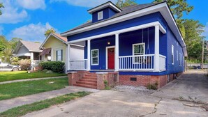 A two-story residential house with a red door, white porch railing, and a blue exterior. - 3 bedroom, 1.5 bathroom single family home in the Historic Highland Neighborhood (Shreveport)