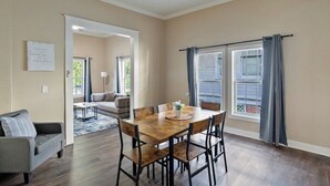 A dining area with a wooden table and chairs, a ceiling fan, and a view of the outdoors through a window with curtains. - 3 bedroom, 1.5 bathroom single family home in the Historic Highland Neighborhood (Shreveport)