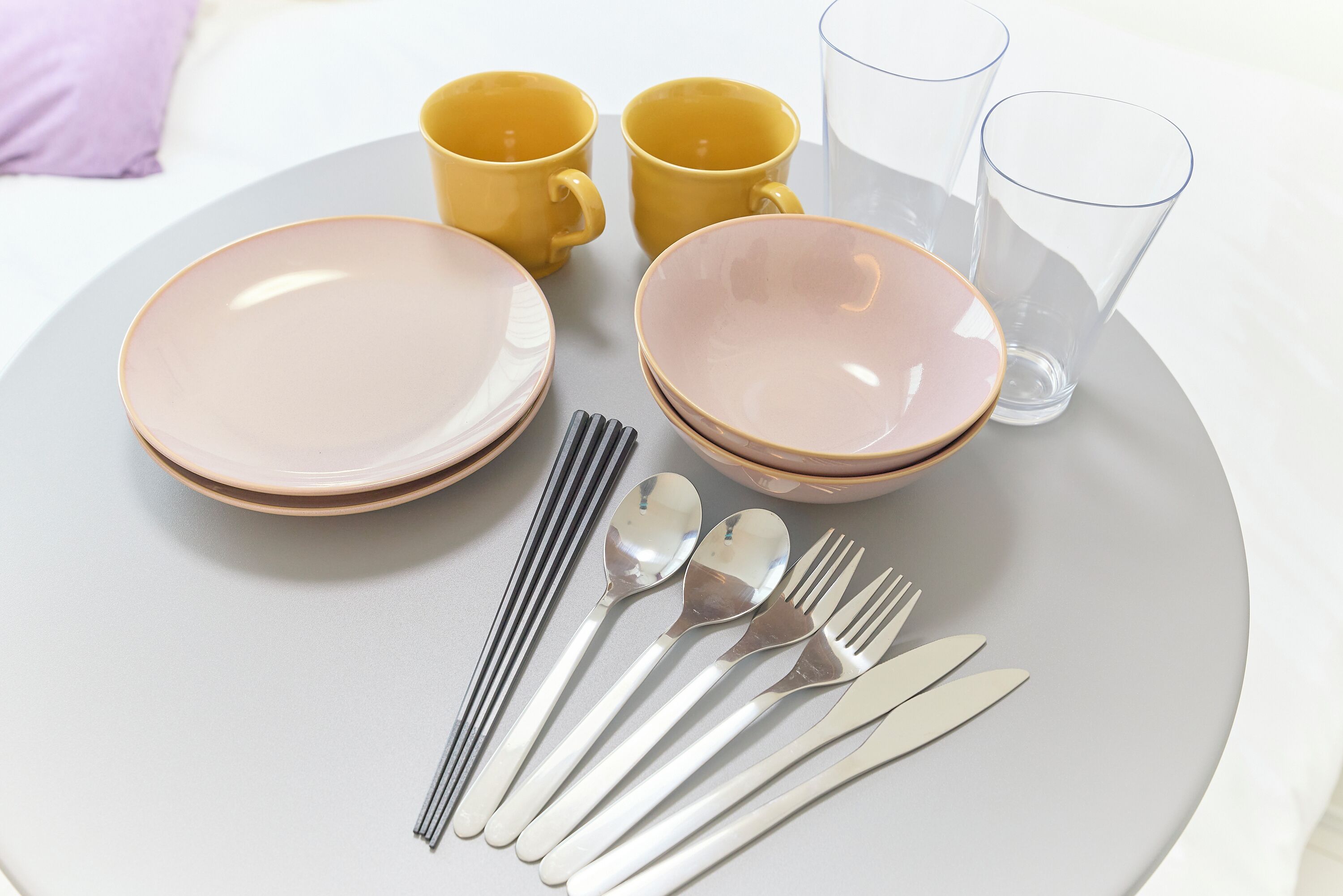 Una mesa dispuesta con platos, tazones, vasos y cubiertos.