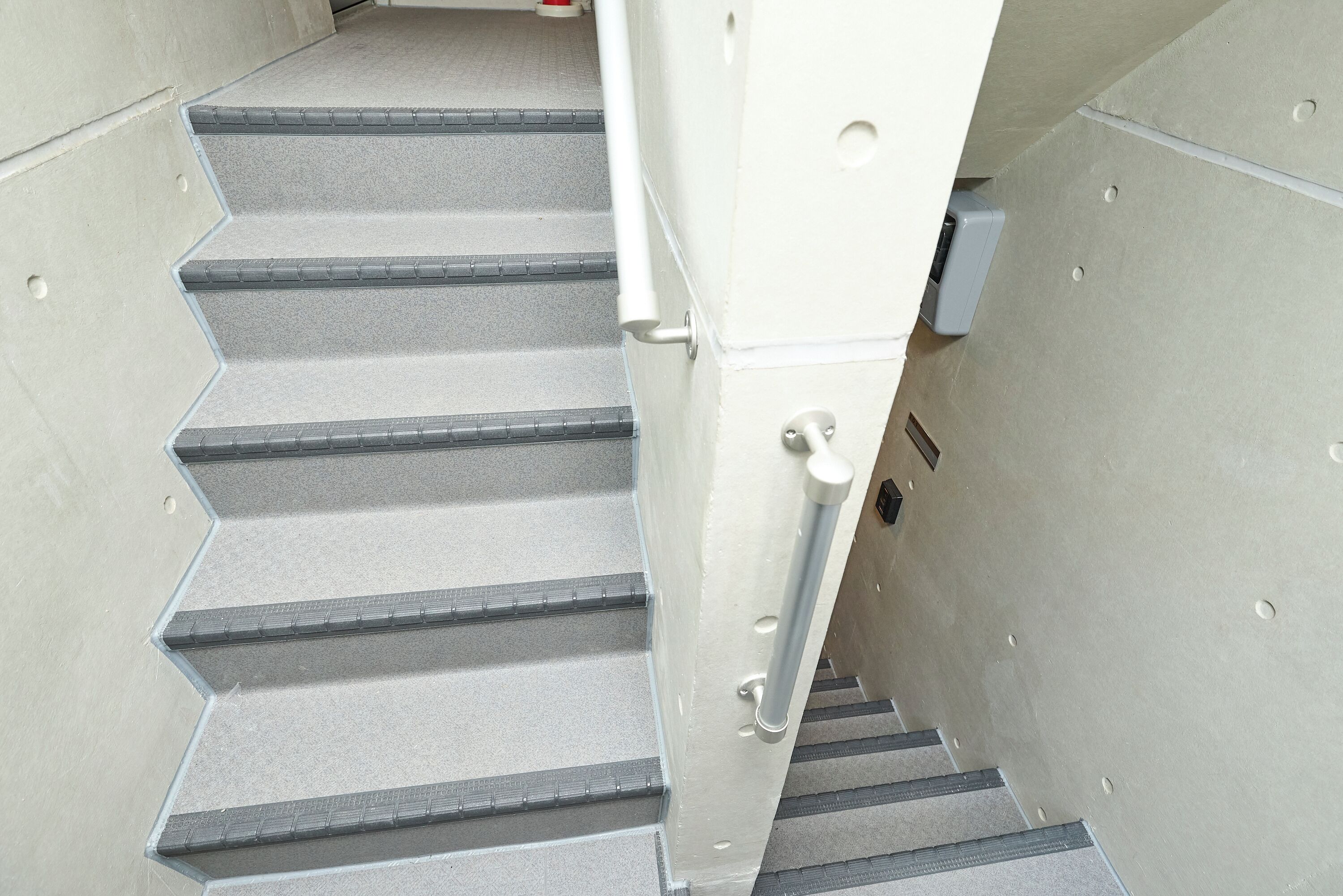 Un conjunto de escaleras con barandilla y una puerta que da a una habitación.