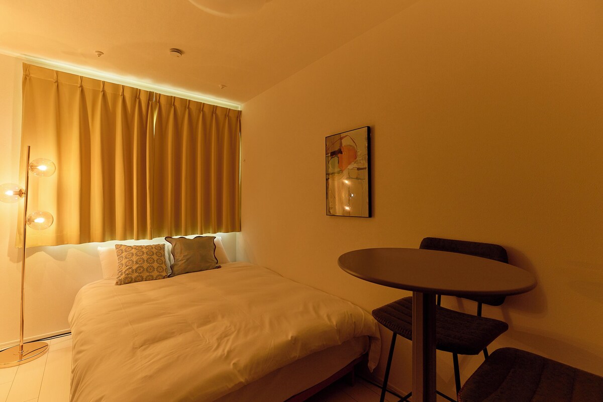 Una habitación de hotel con una cama, una mesa y una silla.