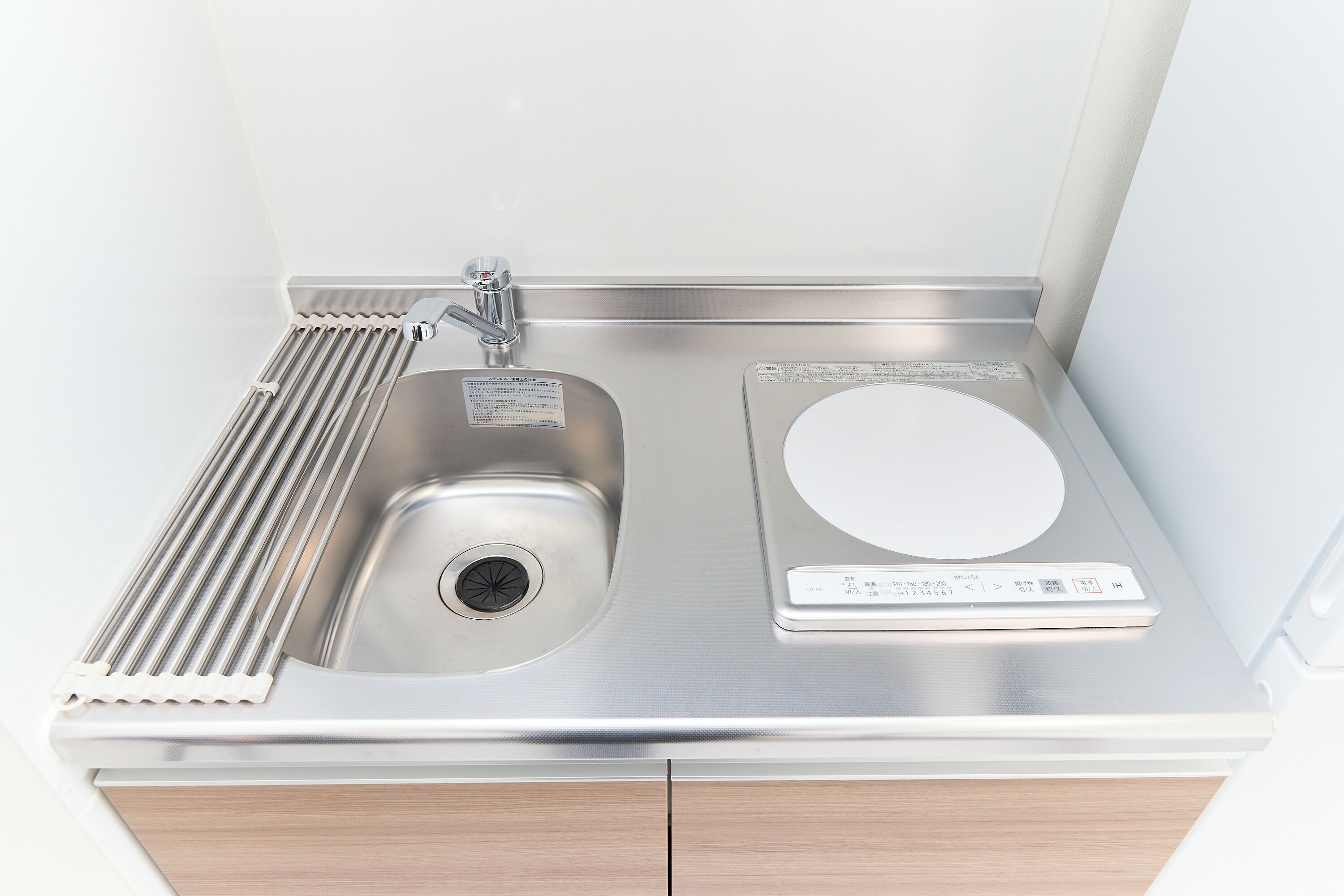 A stainless steel sink with a built-in scale and a hand soap dispenser.