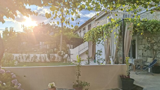 A courtyard with a stone floor, potted plants, a small table, and a staircase leading to a building. - Lovely home in Kucice with house a panoramic view (Kucice)