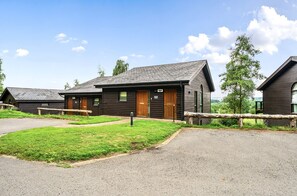 A row of cabins with a gravel driveway and a wooden fence.